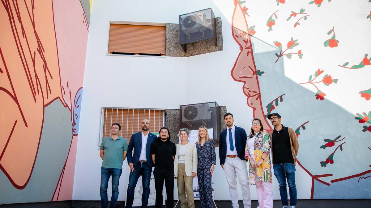 El artista ecuatoriano Mundana junto a autoridades, en el barrio de San Lázaro, Mérida, con su mural al fondo.