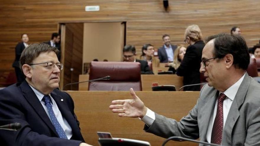 El presidente de la Generalitat, Ximo Puig, dialoga con el conseller de Hacienda, Vicent Soler, en las Cortes.