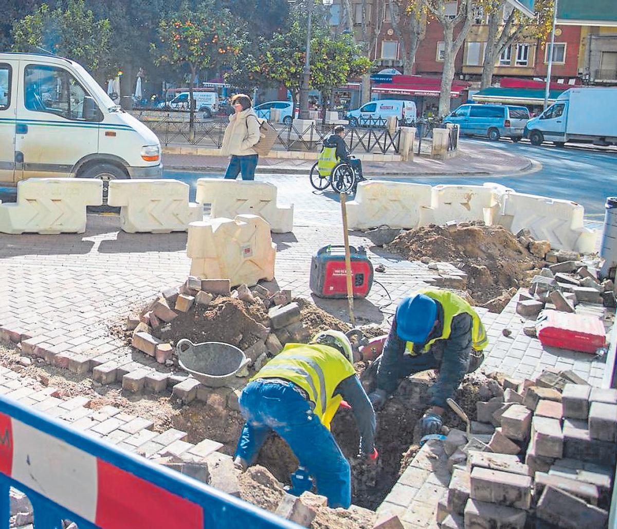 Operarios realizan trabajos municipales sobre el pavimento de una calle del centro de Cartagena