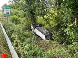 Susto en la carretera de Luanco: los bomberos liberan a una conductora que acabó volcando tras salirse de la vía