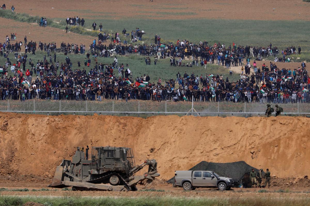 Israeli soldiers patrol next to the border fence on the Israeli side of the Israel-Gaza Strip border, as Palestinians protest on the Gaza side of the border, March 30, 2018. REUTERS/Amir Cohen