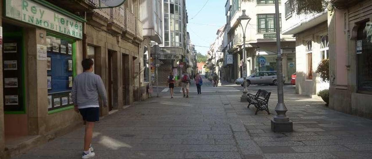 Varias personas transitan por la calle Real, en Caldas. // Noé Parga