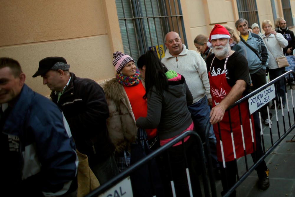 People wait in line to receive food during a ...