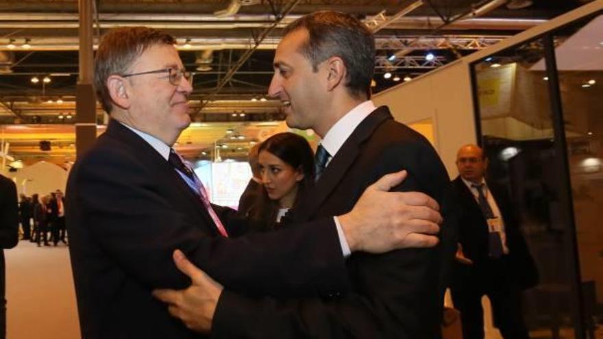 El presidente de la Generalitat y el de la Diputación, ayer, saludándose en el estand de Fitur de la Comunidad Valenciana.