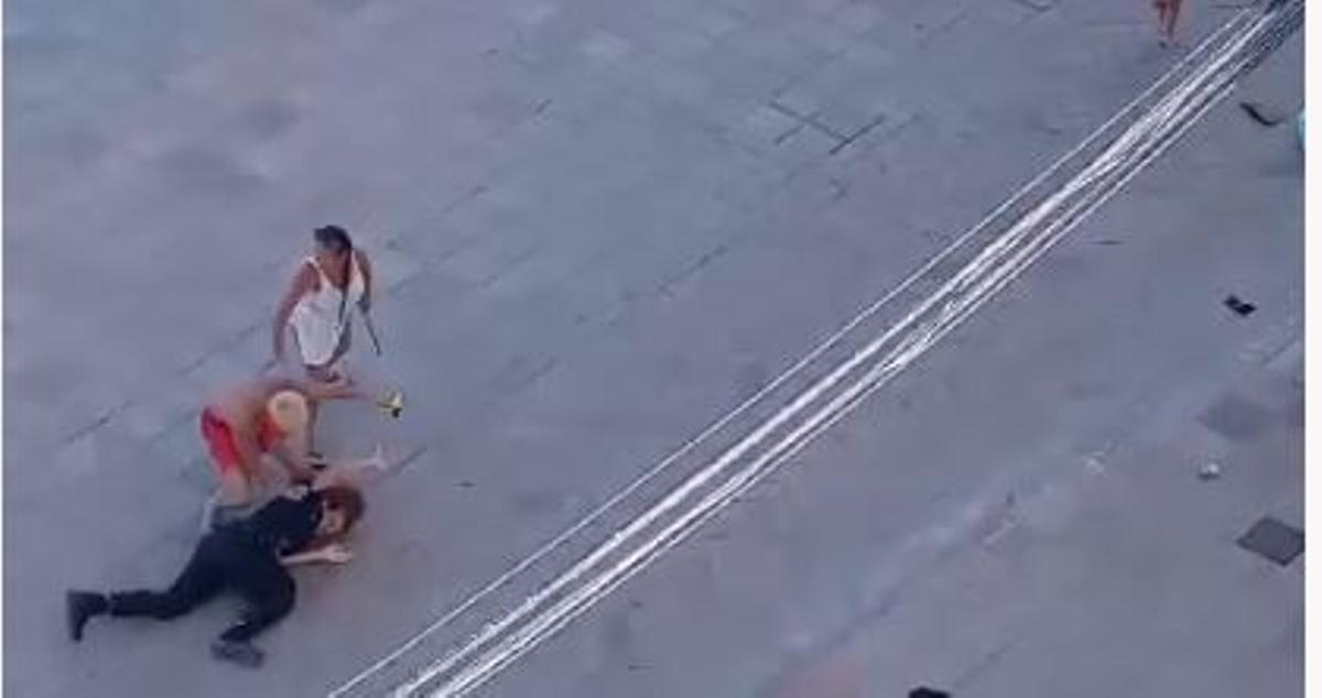 La agente en el suelo después de ser derribada en su intento de respaldar a su compañero de patrulla que estaba siendo agredido