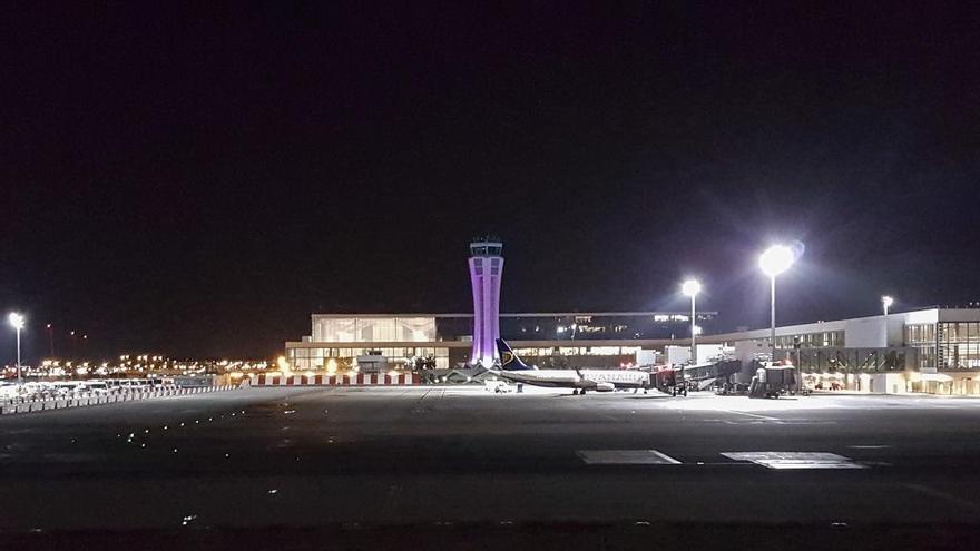 Imagen de la torre de control del aeropuerto de Málaga iluminada de morado.