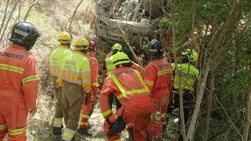 Los bomberos inspeccionan la grúa que se despeñó.