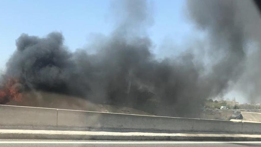 Vehículo ardiendo en la carretera.