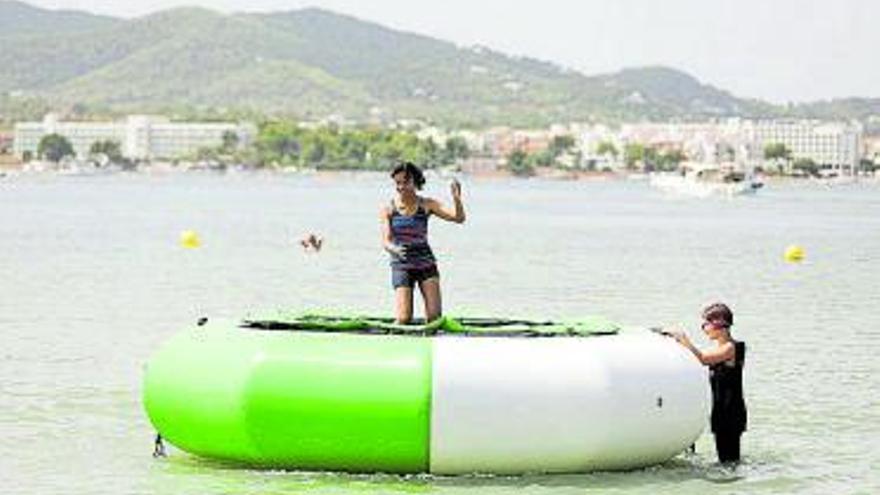 Los jóvenes disfrutan con camas elásticas en el mar.