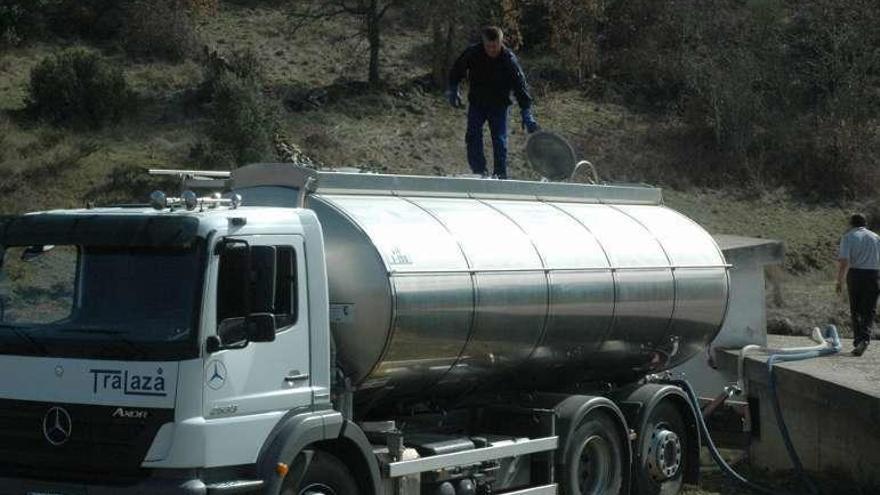 Un camión de Tralaza llena un depósito de agua en un pueblo.