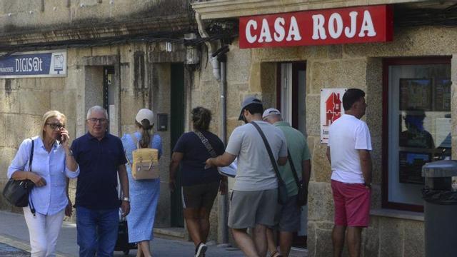 Vecinos, ayer, ante una inmobiliaria ubicada en el centro de Cangas. | GONZALO NÚÑEZ