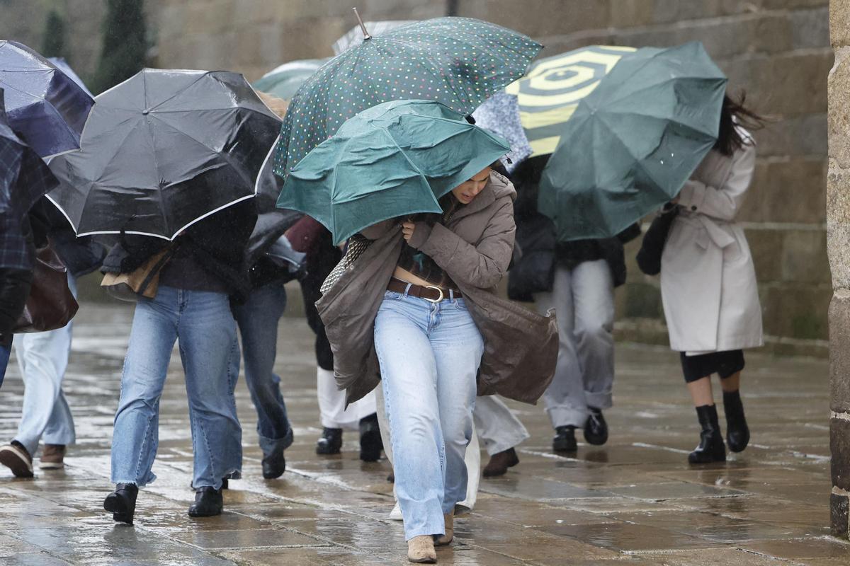 Varias personas se protegen de la lluvia, ese miércoles en Santiago de Compostela.