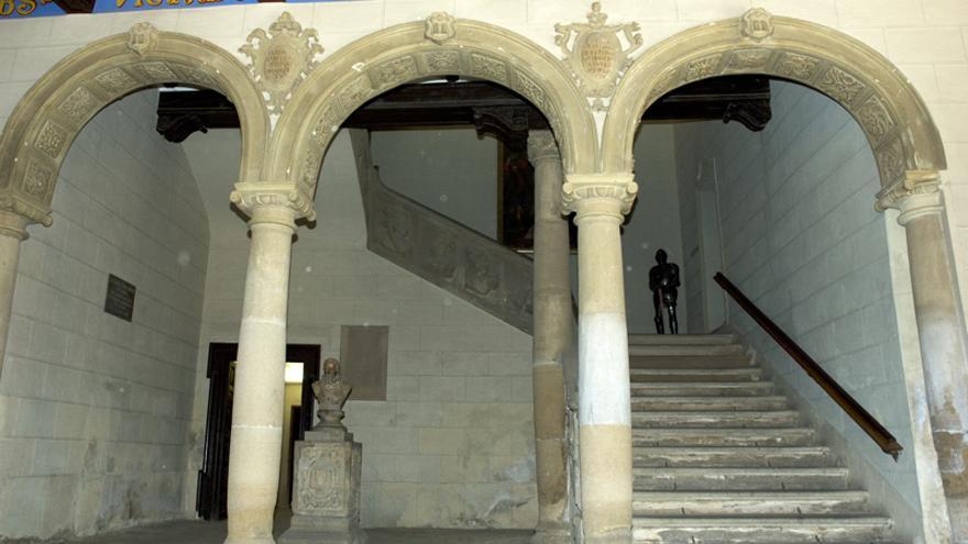 Al fondo, detrás del pedestal y el busto, la placa dedicada a Franco en el Ayuntamiento de Huesca.