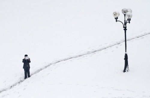 A man films with a tablet device after heavy snowfall in Kiev