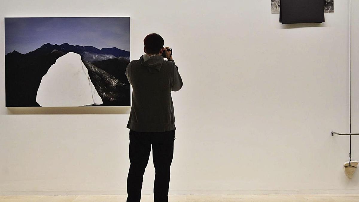 Un visitante fotografía un aspecto de la muestra