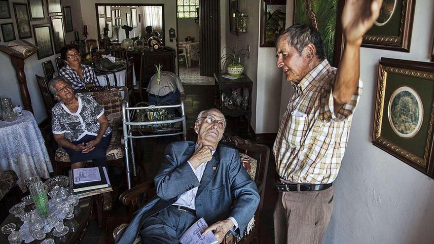 El padre Pérez, sentado, escucha a un vecino, en presencia de dos voluntarias de Padrinos Asturianos, en uno de sus últimos viajes a Colombia.