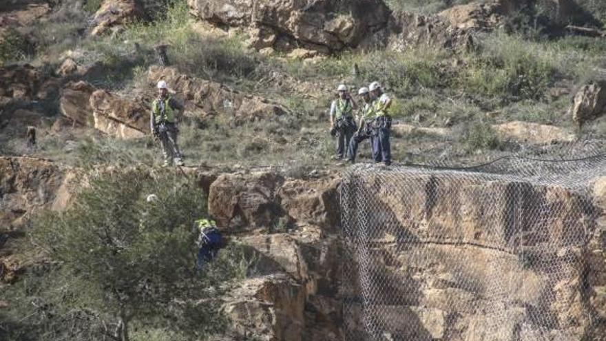 Los operarios trabajan junto al túnel de la N-340 para instalar mallas que viten la caída de rocas