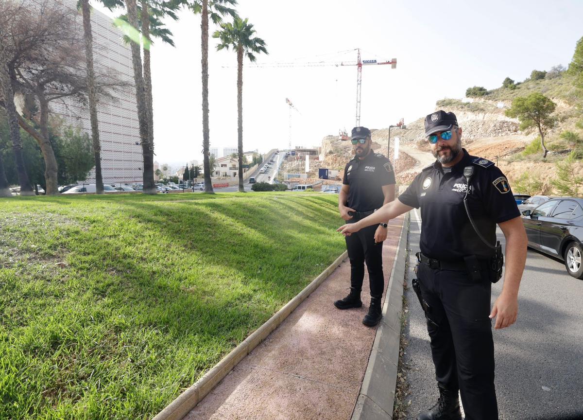 Los dos agentes de la Policía Local de Benidorm señalan el césped de la rotonda en la que ha tenido lugar el parto.