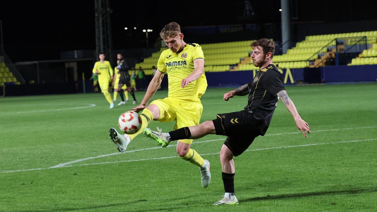 El central catalán Hugo Pérez despeja un balón ante la mirada de un jugador del Intercity.