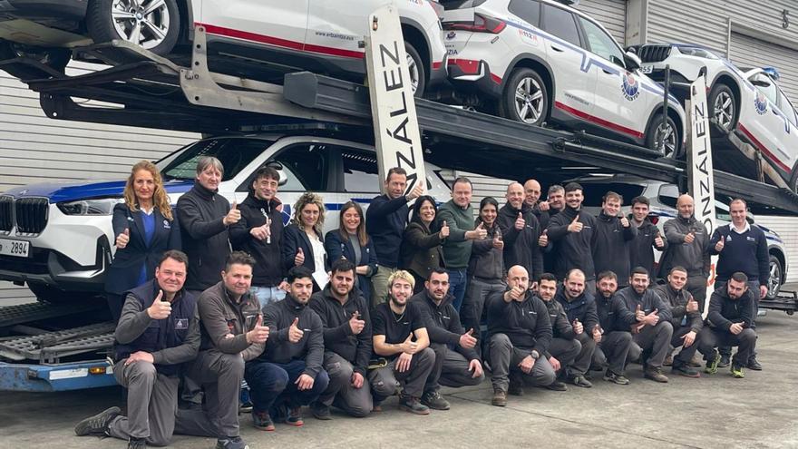 Trabajadores de Autosa posan con un lote de los coches preparados para la Ertzaintza antes de partir para el País Vasco.