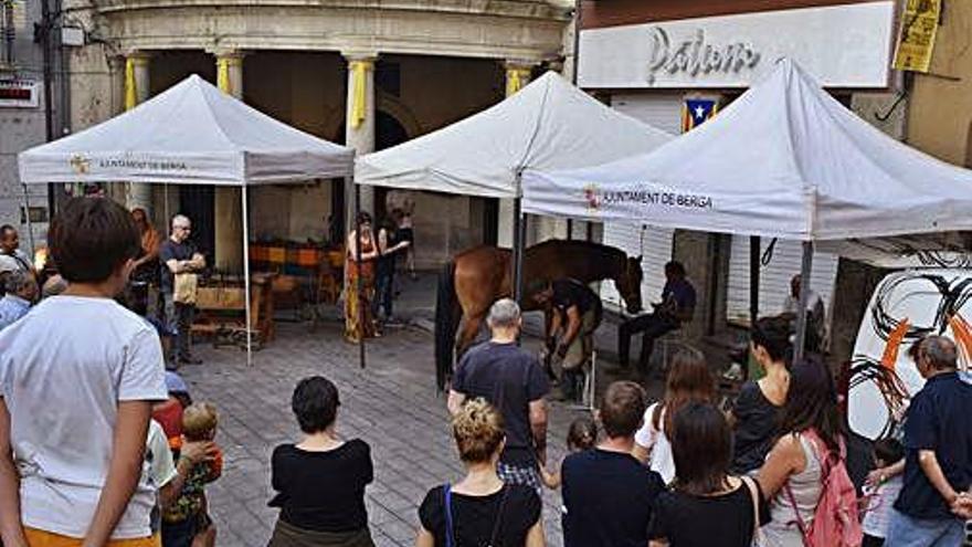 Assistents observant el canvi de ferradura a la plaça de Sant Pere