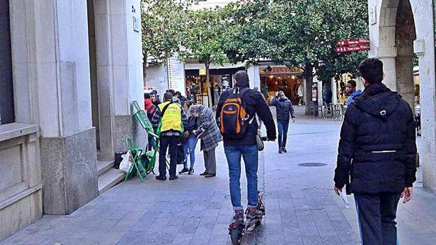 Un usuari de patinet elèctric accedint a la plaça de l&#039;Ajuntament, d&#039;ús exclusiu per a vianants.