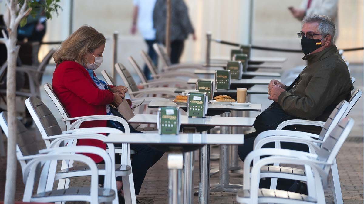 Personas con mascarilla en la terraza de un bar, en Málaga