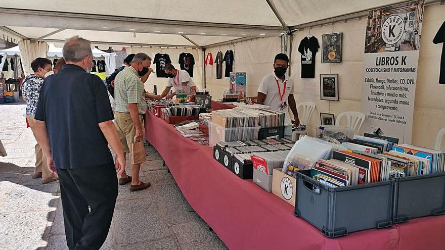 Expositor que ofrece discos, libros y otros objetos en la feria. | M. J. C.