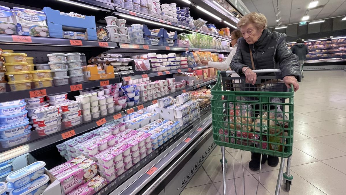 Una mujer ante la sección de lácteos de un supermercado de Mercadona.