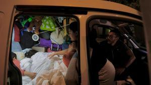 Una familia duerme en una furgoneta con sus dos hijos pequeños.