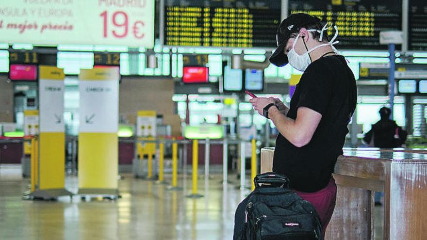 Un joven aguarda para embarcar en un aeropuerto de Los Rodeos sin apenas movimiento.