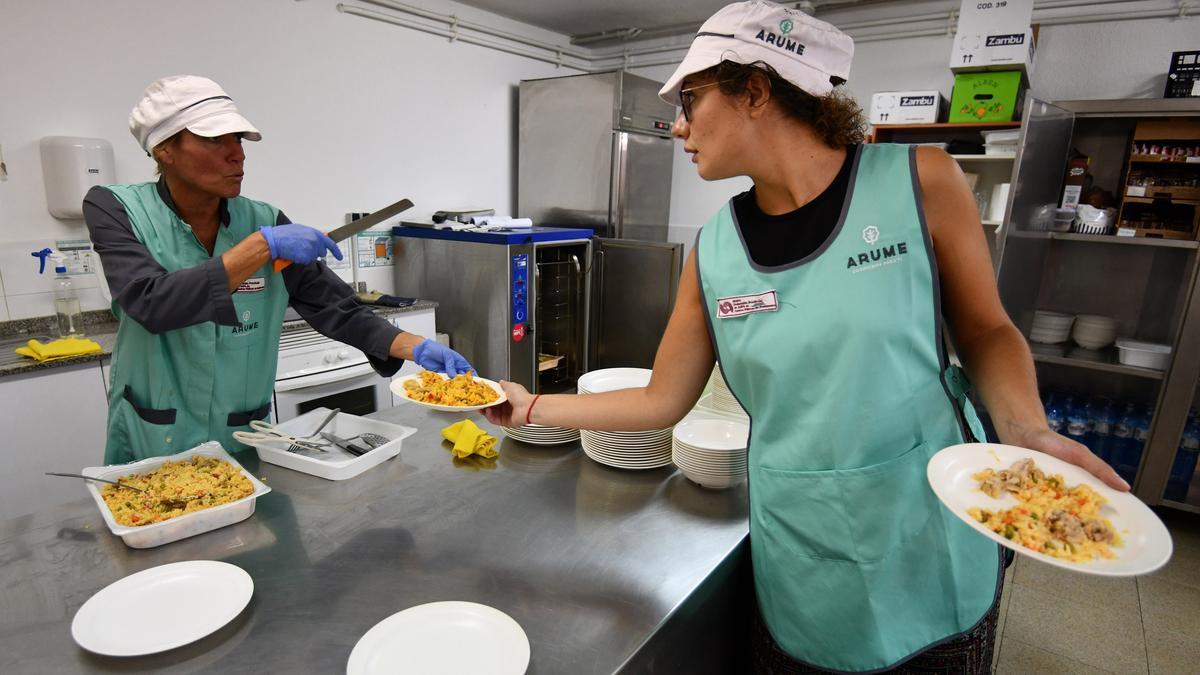 Un comedor escolar de Pontevedra: personal sirviendo platos a las mesas.