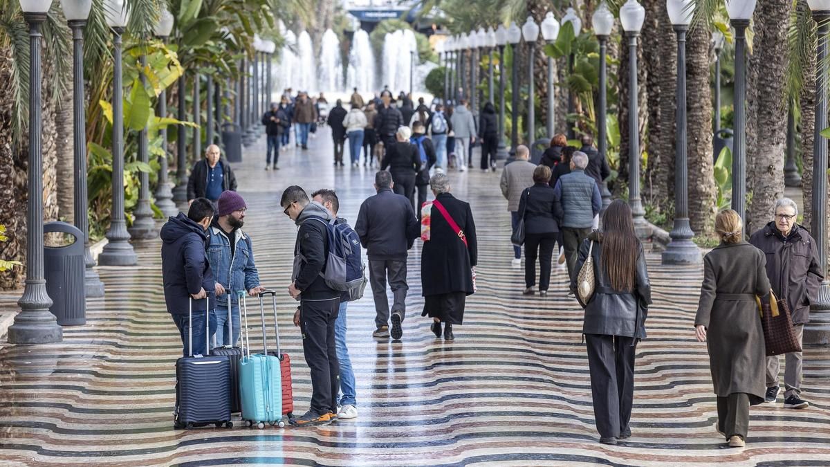 Ciudadanos transitan por el paseo de la Explanada de la ciudad de Alicante, algunos de ellos con maletas, en una imagen reciente.