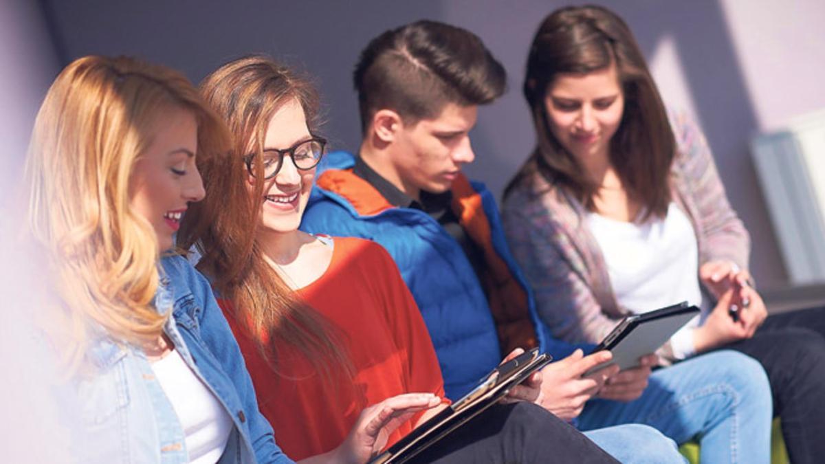 Estudiantes universitarios repasan sus apuntes en tabletas móviles