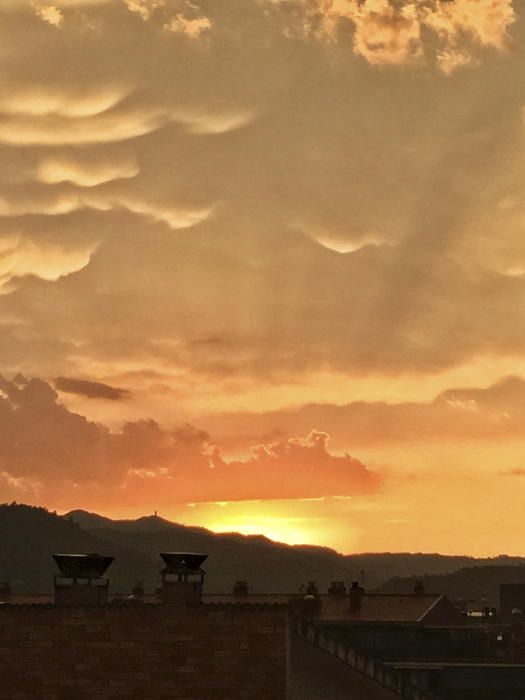 Després de la tempesta. Un cel ataronjat amb alguns núvols sobre els teulats de Sallent.