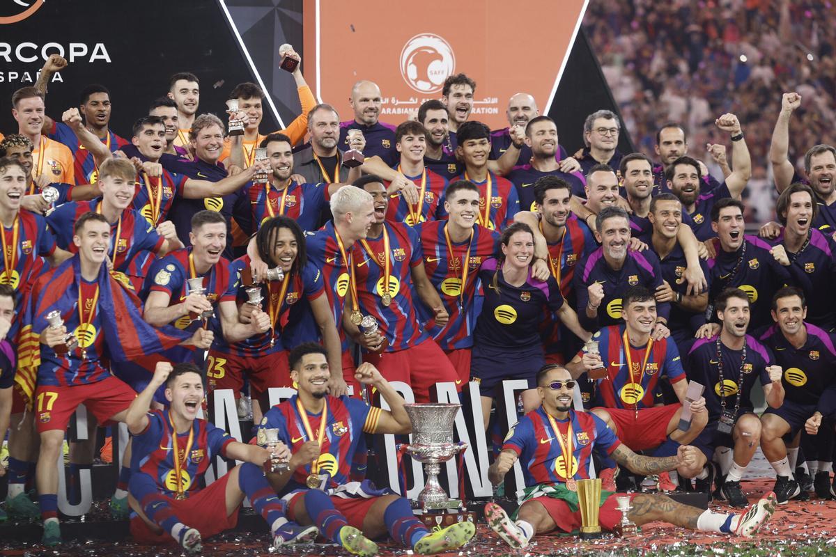 Los jugadores del FC Barcelona levantan el trofeo de campeón tras ganar 3-2 la final de la Supercopa de España contra el Real Madrid.