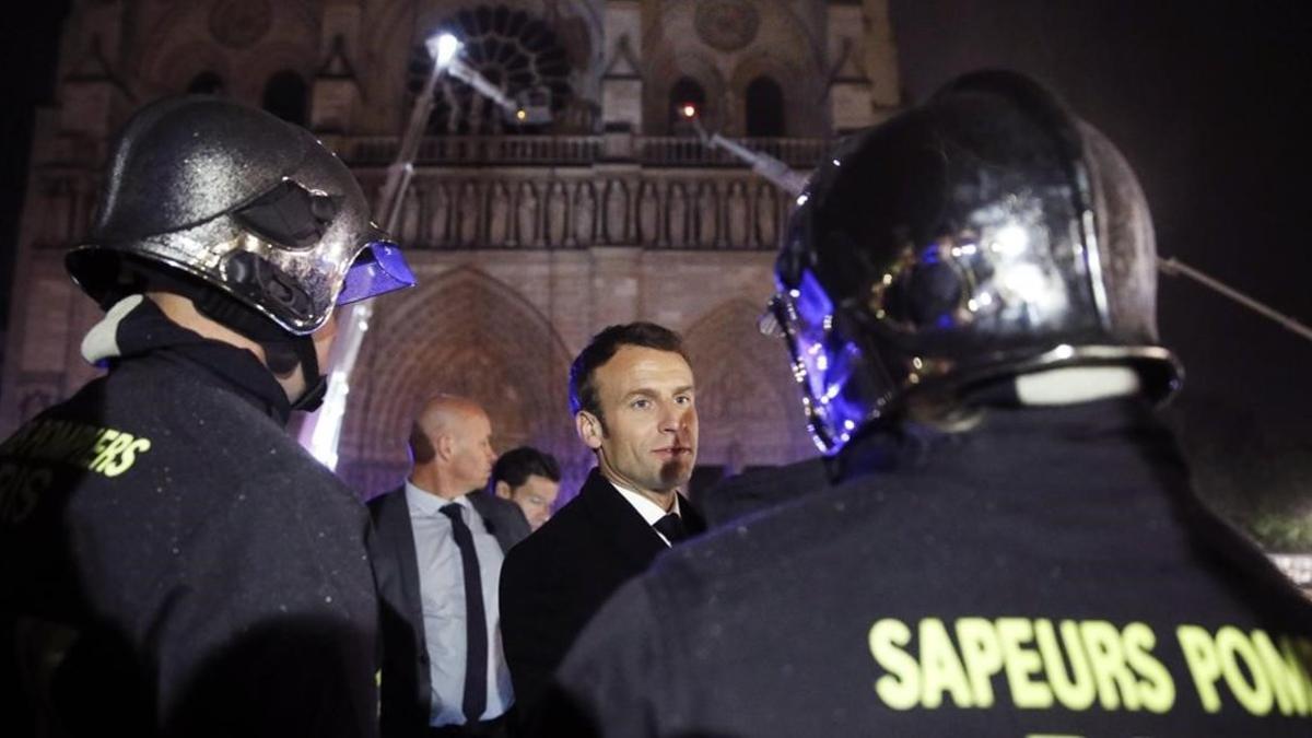 El presidente de Francia  Emmanuel Macron, habla con los bomberos que intentan apagar el incendio en la catedral de Notre Dame, en París, el pasado abril.