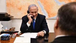 El primer ministro israelí, Binyamin Netanyahu, sonríe mientras habla con Donald Trump por teléfono, en una imagen de 2019.