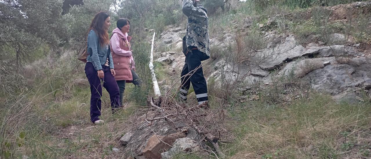 Miembros de Ciriana en la Sierra de Churriana, con una tubería tapada en parte con ramas secas y piedras, hace justo una semana.