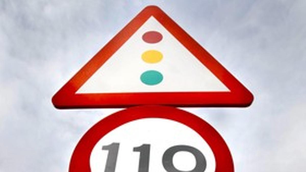 Un operario coloca un adhesivo de 110 km/h sobre una señal de 120 km/h, el pasado febrero en Alicante.