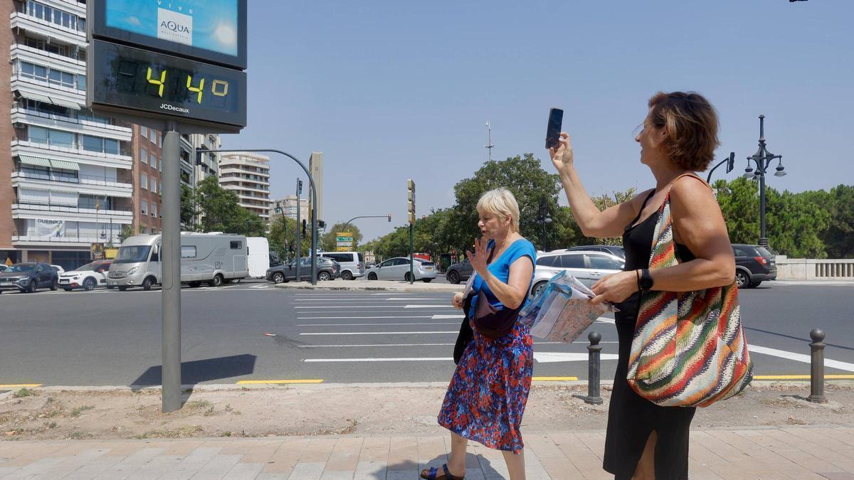 Una mujer fotografía el termómetro en una ola de calor el verano pasado en València.