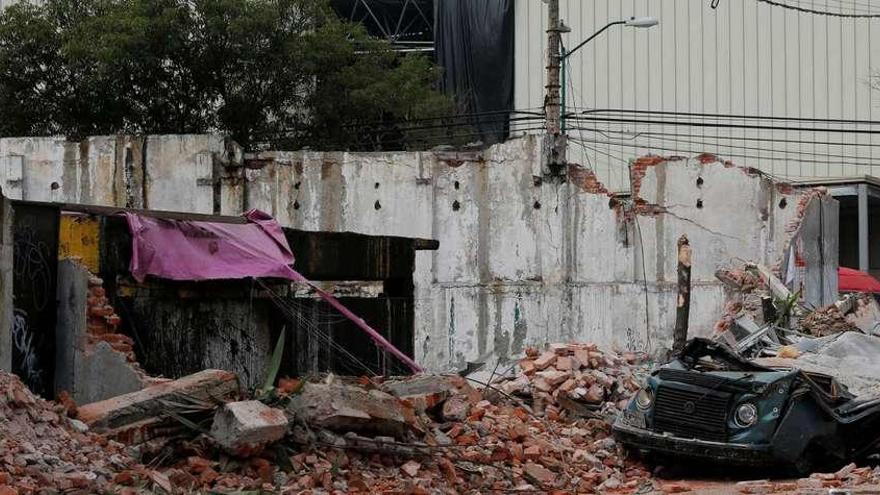 Un coche aplastado por los escombros de un edicio tras el paso del devastador terremoto, en Ciudad de México. // Reuters