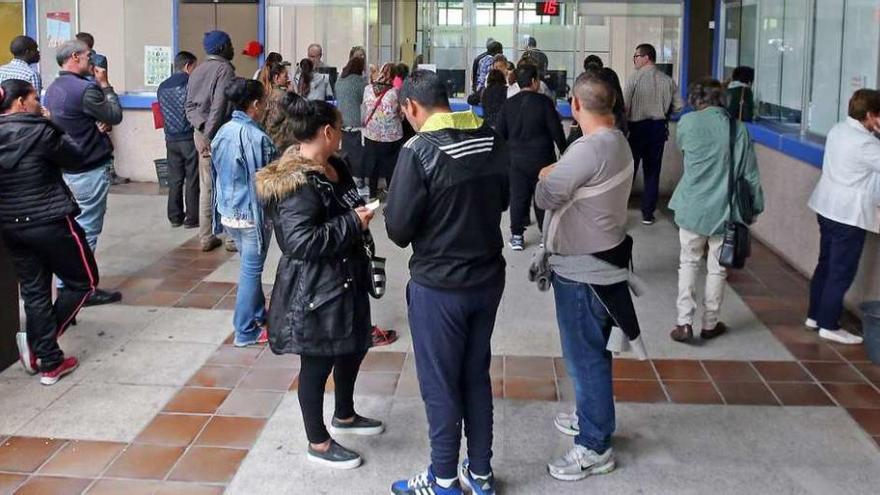 Beneficiarios del cheque social esperando su turno ayer en la Lonja del Concello. // Fotos: Marta G. Brea
