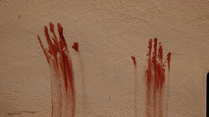Las manos manchadas de sangre en la pared de una calle de Gomila.