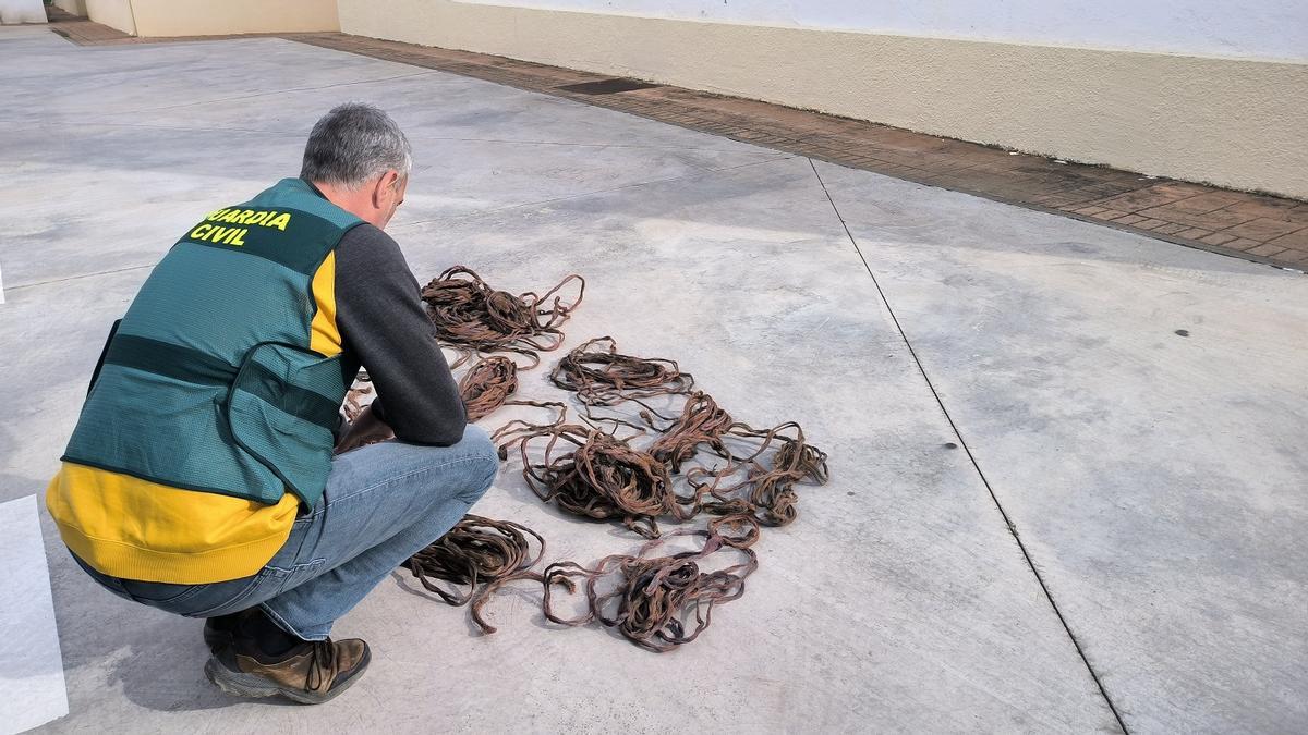 Un agente inspecciona el cable recuperado.