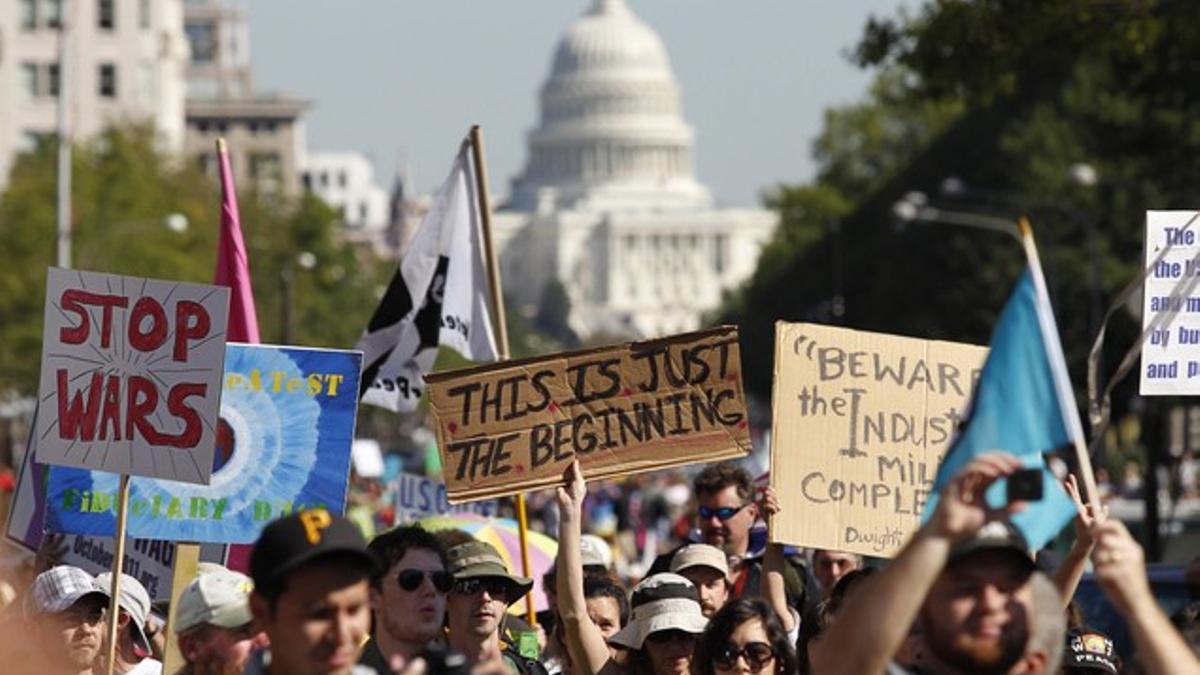 Cientos de personas participan en la marcha de protesta, el jueves en Washington, con el Capitolio al fondo.