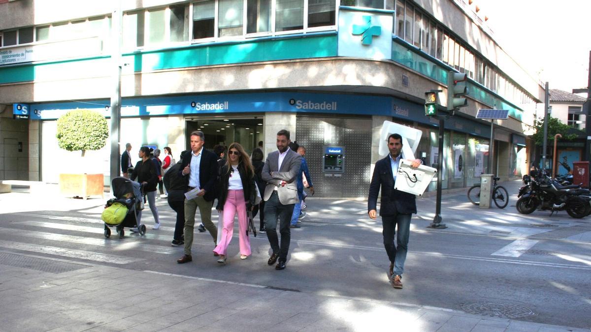 Los número uno, dos y tres de la candidatura del PP junto al jefe de prensa, con el atril al hombro, camino de la Alameda de la Constitución, donde este viernes ofrecían una rueda de prensa.