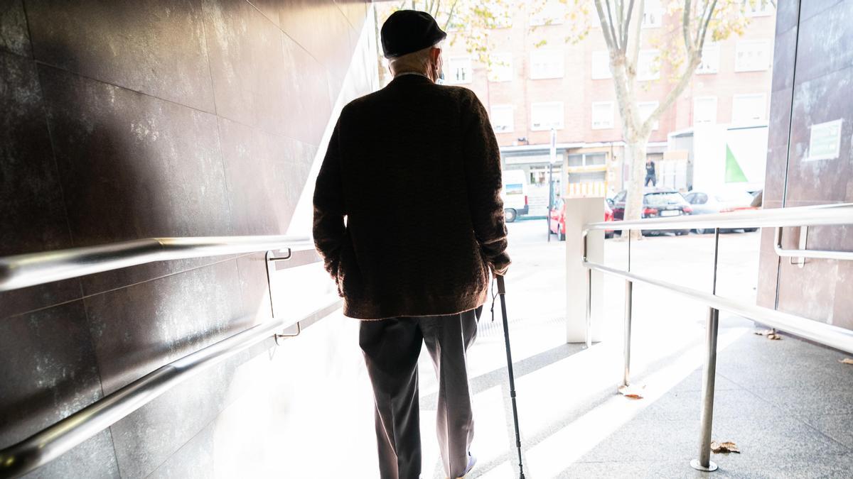 Una persona mayor sale de un centro de Salud.