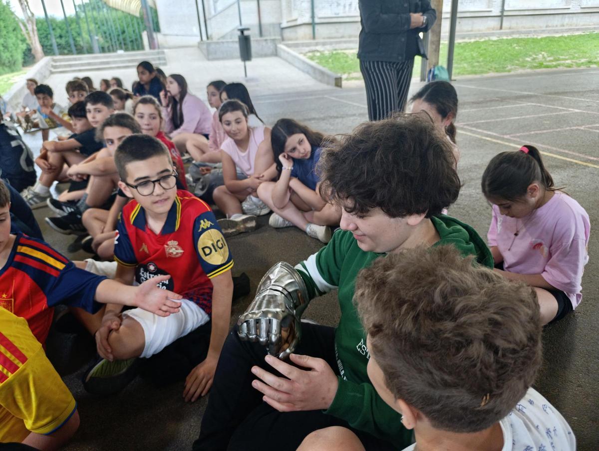 Uno de los alumnos con uno de los guantes de una de las armaduras.