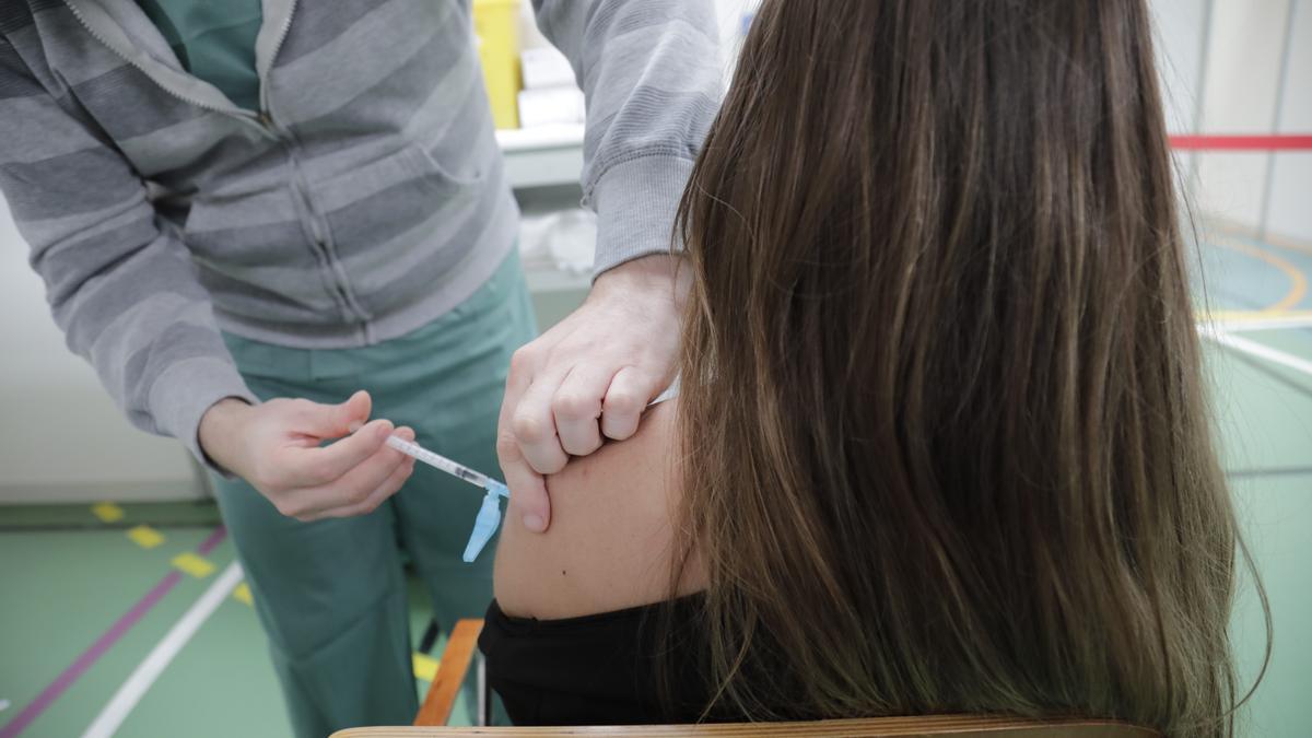 Una joven recibe una dosis de la vacuna AstraZeneca en el polideportivo Germans Escales de Palma